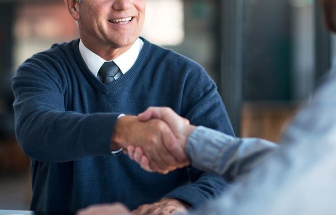 オフィスで握手を交わすビジネスマン
