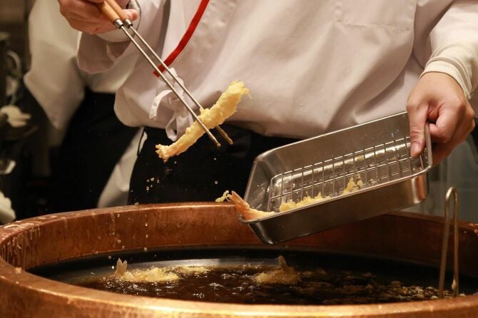 「天ぷら定食まきの」の従業員が天ぷらを揚げる様子