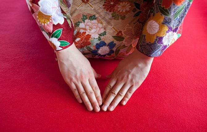 三つ指をついてお辞儀をする舞妓