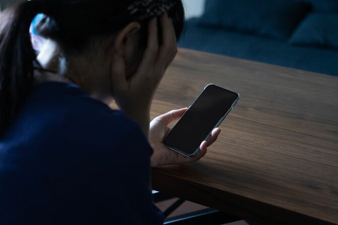 電話の着信に怯える女性