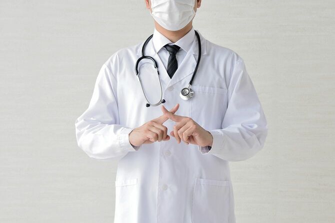 指を交差する医師