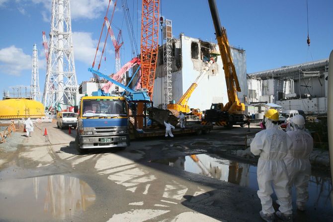 クレーンを使って、がれき除去作業が進む東京電力福島第1原子力発電所4号機原子炉建屋。左端は格納容器のふた＝2012年10月12日、福島県［代表撮影］