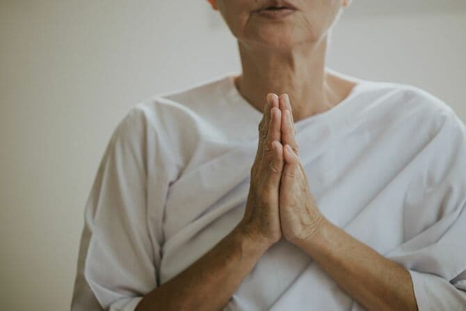 祈りをささげる仏教徒のシニア女性