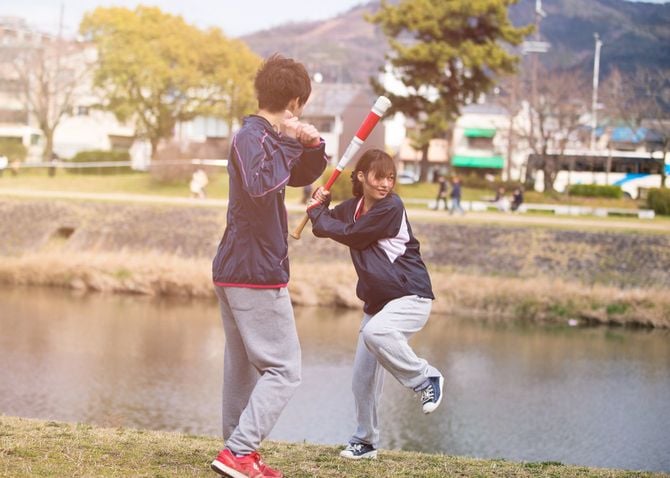 京都・宇治川の土手で野球の練習に励む女子学生