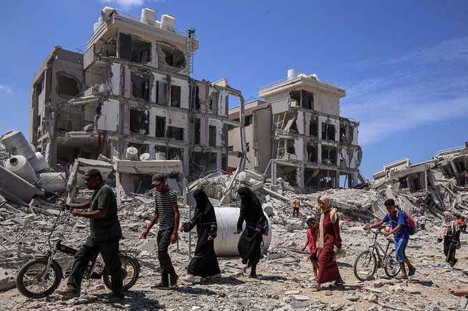 2024年8月29日、ガザ地区中部のデイル・アル・バラで、自宅に戻る避難民