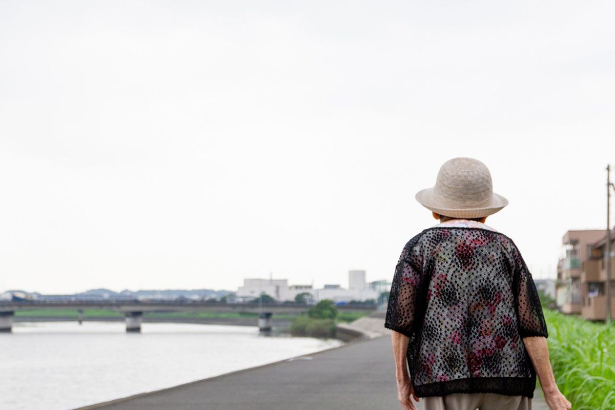 川のそばを散歩する日本人高齢者