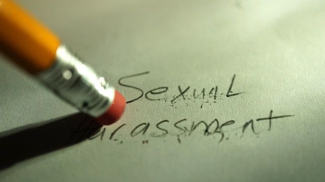 セクシャルハラスメントと書いた文字を、鉛筆についた消しゴムで消そうとしている
