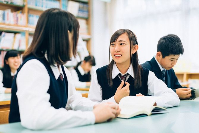 学校図書館で一緒に勉強する日本人女子学生