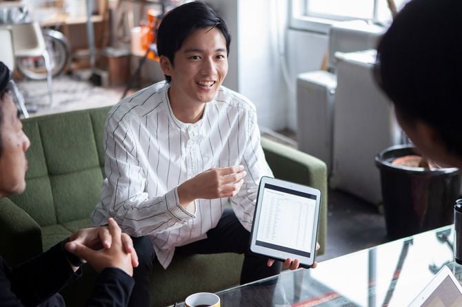 ミーティングで中心になって話す若い男性