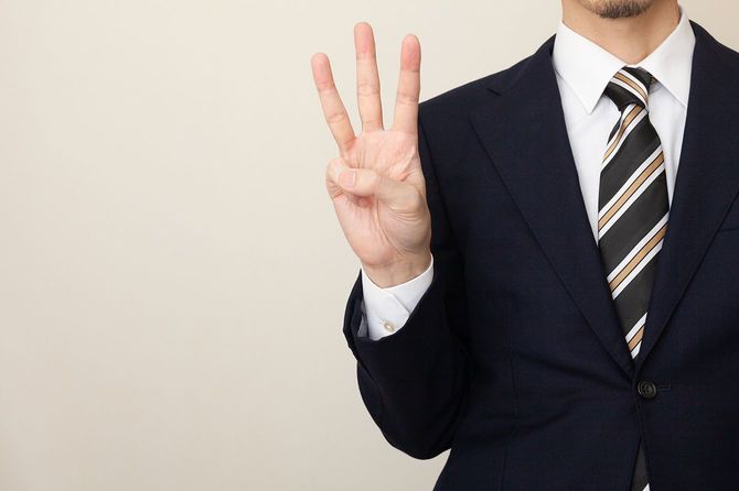 本の指を持つスーツを着た男
