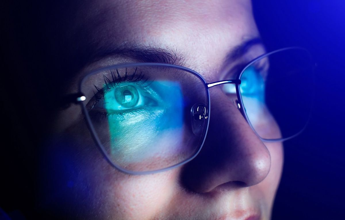 女性のかけている眼鏡に映るブルーライト