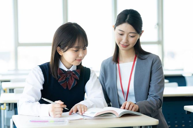 勉強している女子学生と教師