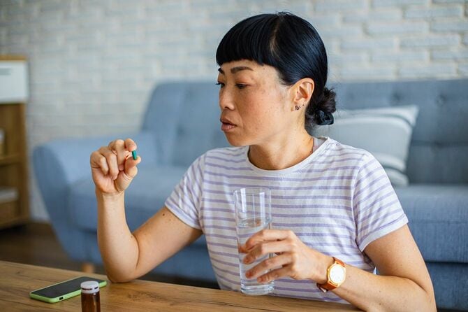 薬を飲む準備をしている女性