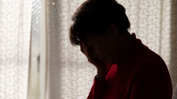 うつむいて顔を覆う女性