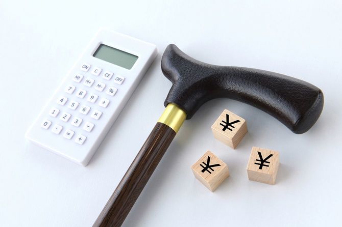 電卓と日本円マークの木のブロックと杖