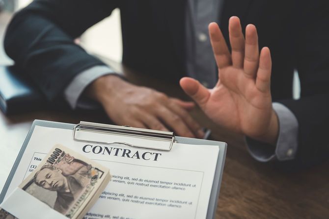 契約によって来るお金を拒絶するビジネスマン