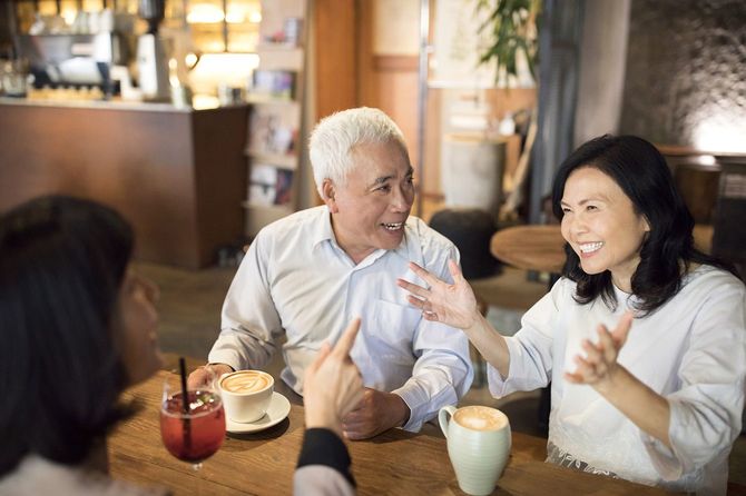 カフェで楽しい時間を過ごしている中年の男女