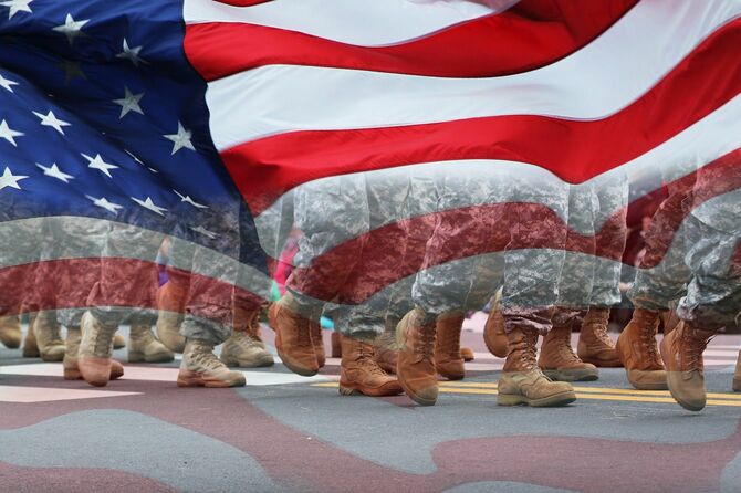星条旗で覆われた、米軍のパレードをする軍人たちの足元