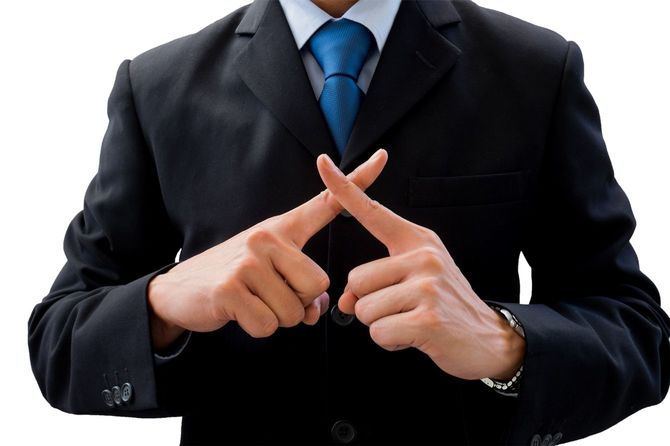 指をバツの字にするビジネスマン
