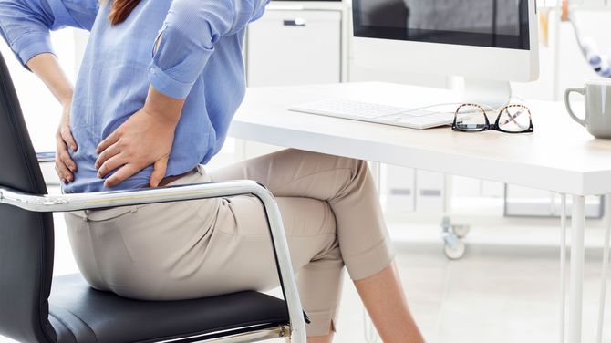 椅子に座って腰に手を当てている女性