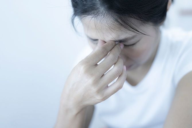 目頭をおさえるうつ病の女性