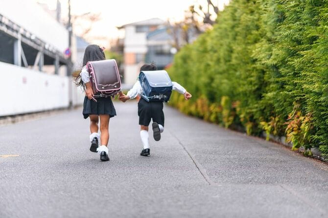 手をつないで走る日本の小学生