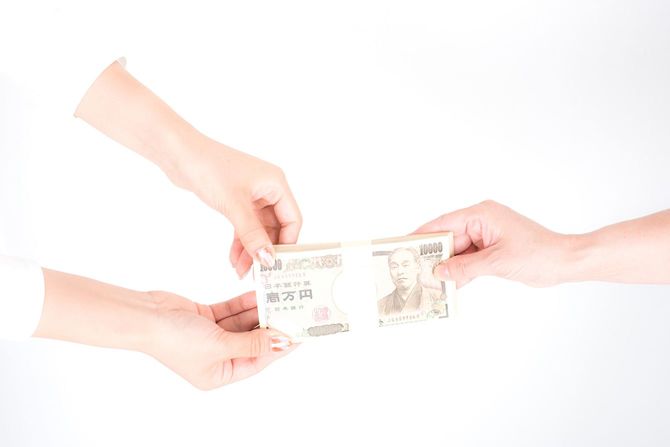 100万円の札束を手渡す手元