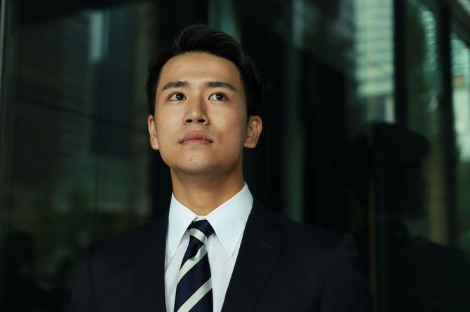 オフィスビルの外に立つビジネスマン