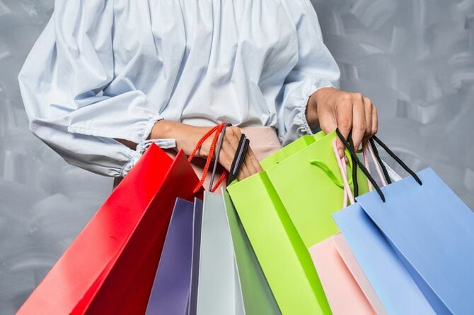 たくさんのショッピングバッグを手にする女性