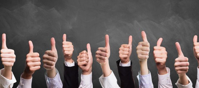 黒板の前でたくさんのサムズアップ