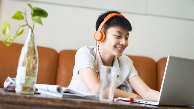 自宅でオンラインレッスンを受ける笑顔の男子生徒