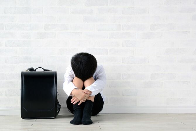 居間に一人で座っているうつ病の子供