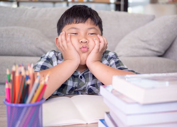自宅学習に飽きてしまった少年がふてくされている