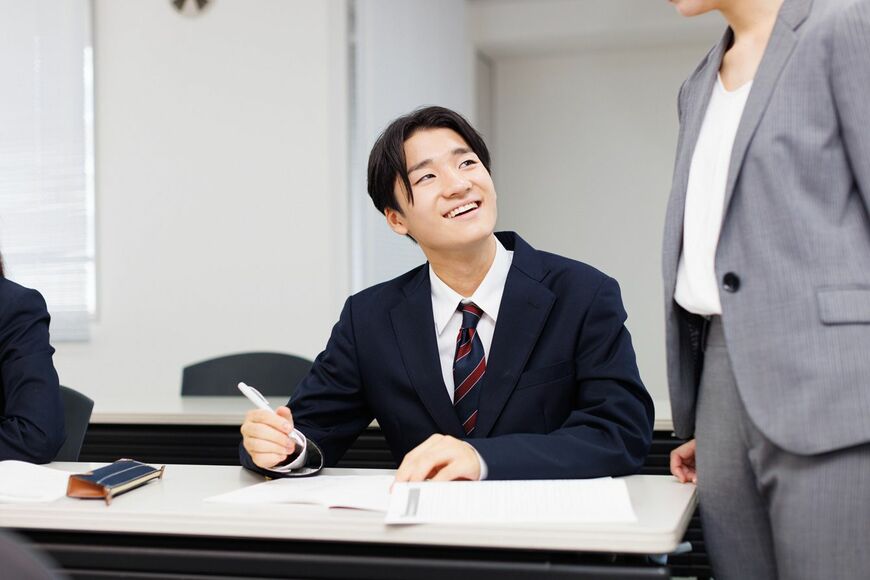 先生と笑顔で勉強をする学生