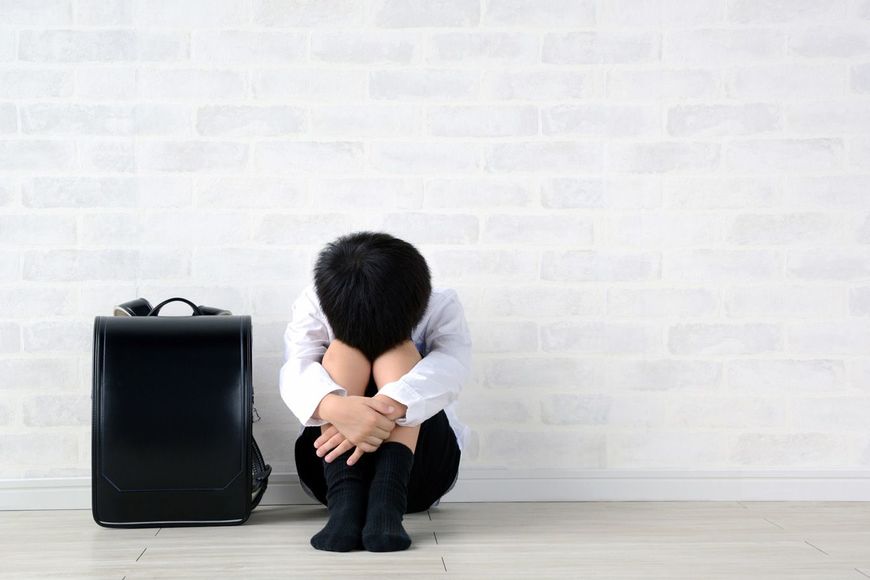 居間に一人で座っているうつ病の子供