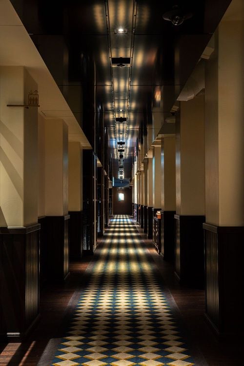 当時の雰囲気を伝える廊下。床の意匠を天井に映り込ませ、配管を隠した