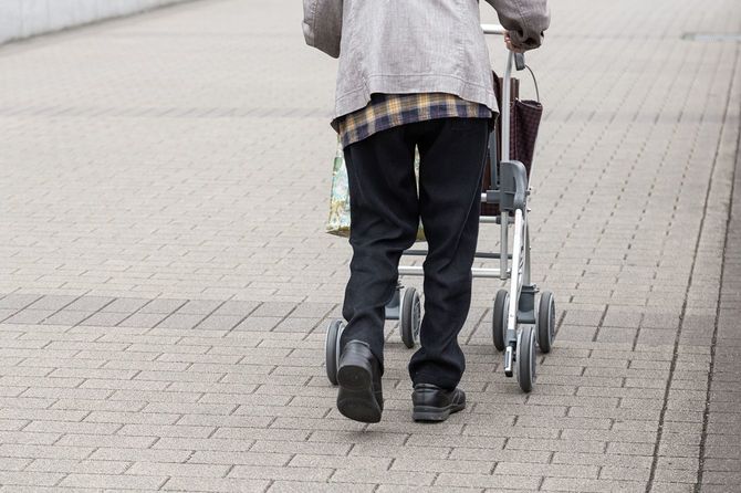 歩行補助器を使って歩く高齢者