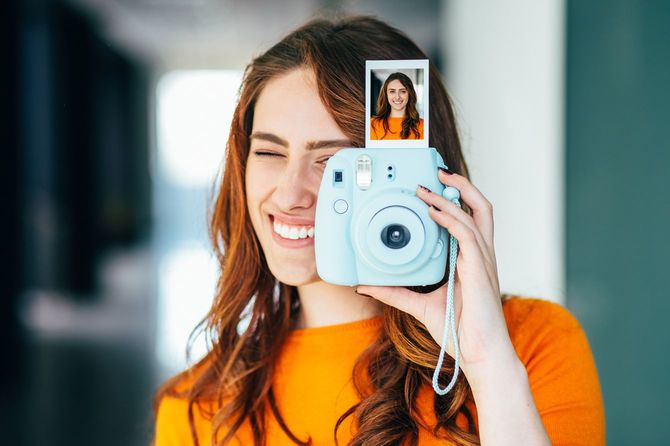 インスタントカメラで写真を撮る女性