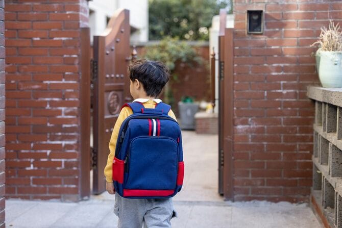 学校から帰ってくる小さな男の子