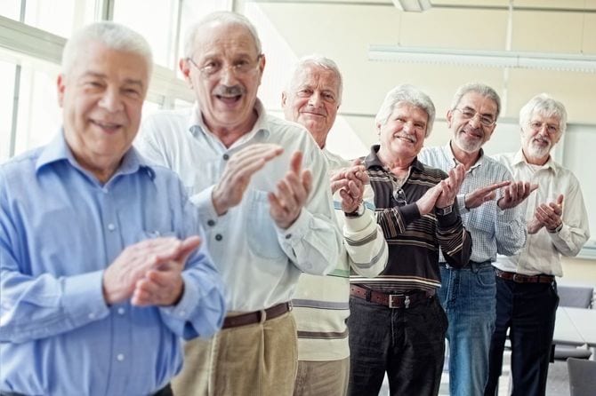 並んで拍手するシニアのグループ