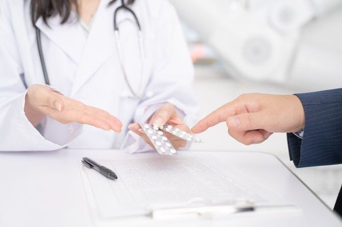 患者に処方箋の説明をしている女性医師