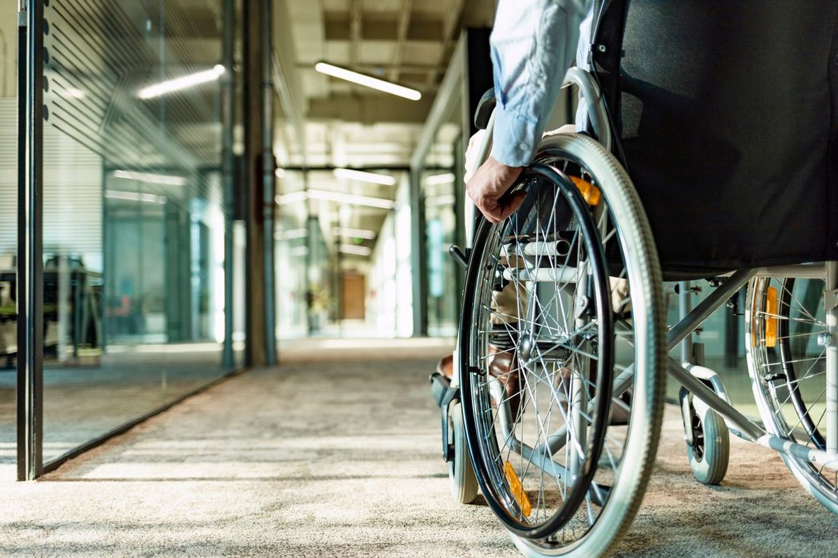 オフィス内を車椅子で移動中の男性