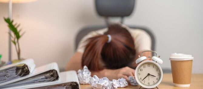 デスクに伏している女性