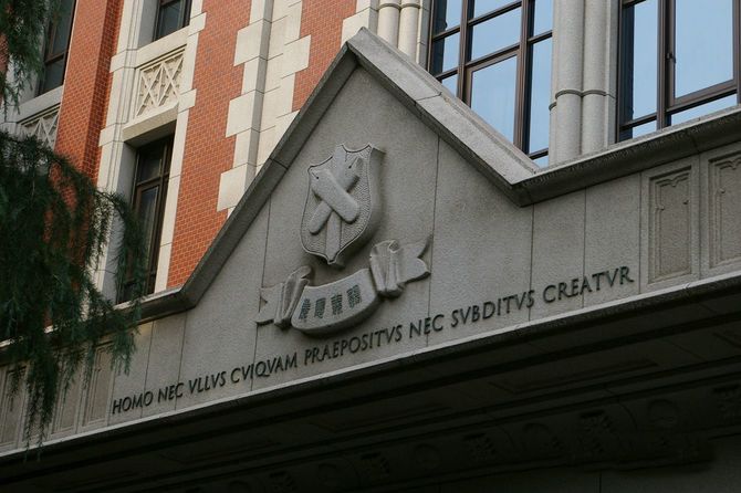 慶応義塾大学三田キャンパス東館正面に刻まれたロゴと文字