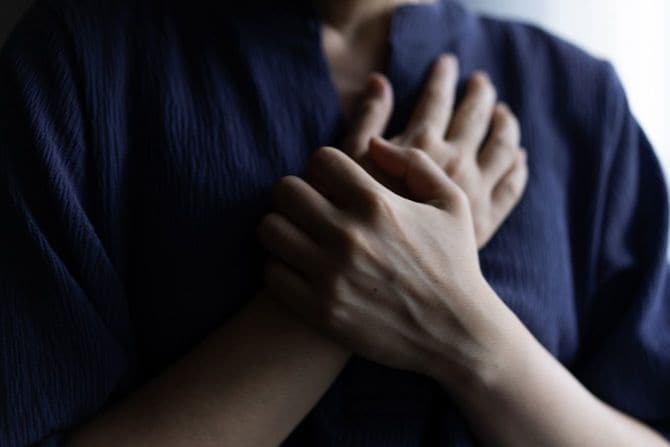 胸元を押さえている女性