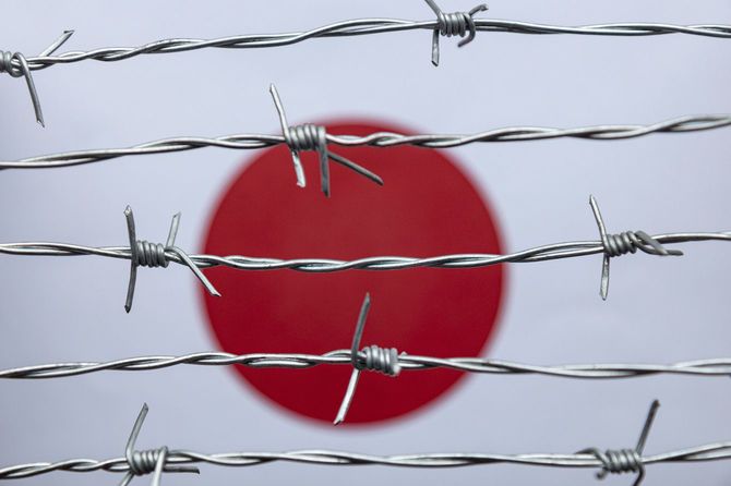 有刺鉄線の張られた日本国旗