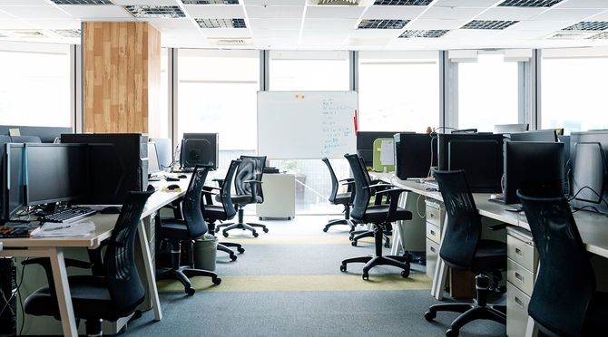 オフィスのデスクで空の椅子とデスクトップPC