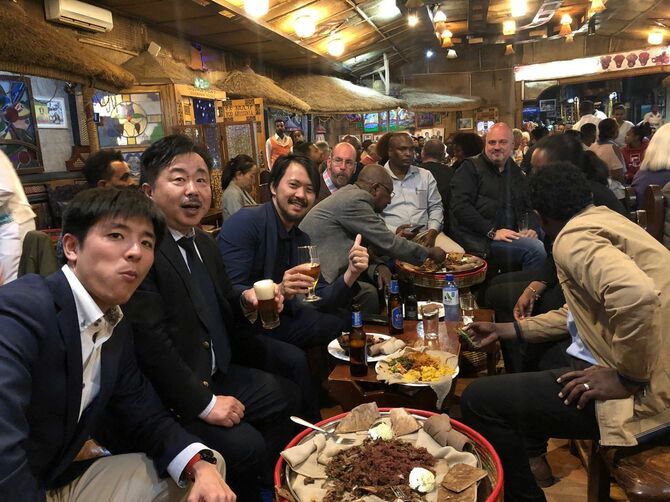 エチオピアで同僚たちと食事をする中川さん（左から2人目）