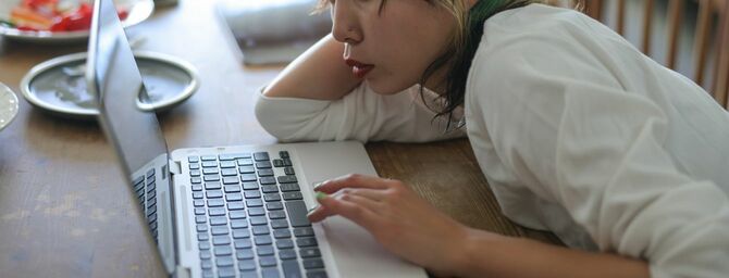 ノートパソコンの画面を見つめる若い女性