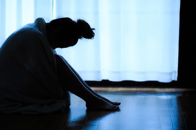 窓際に座って孤独な女性